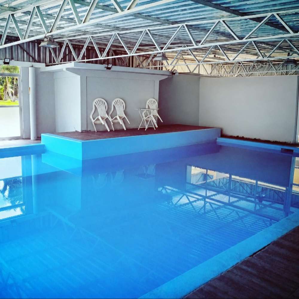 Covered heated pool with clear blue water at Hotel Imperador Caldas